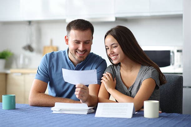Couple reviewing a letter together at their kitchen table